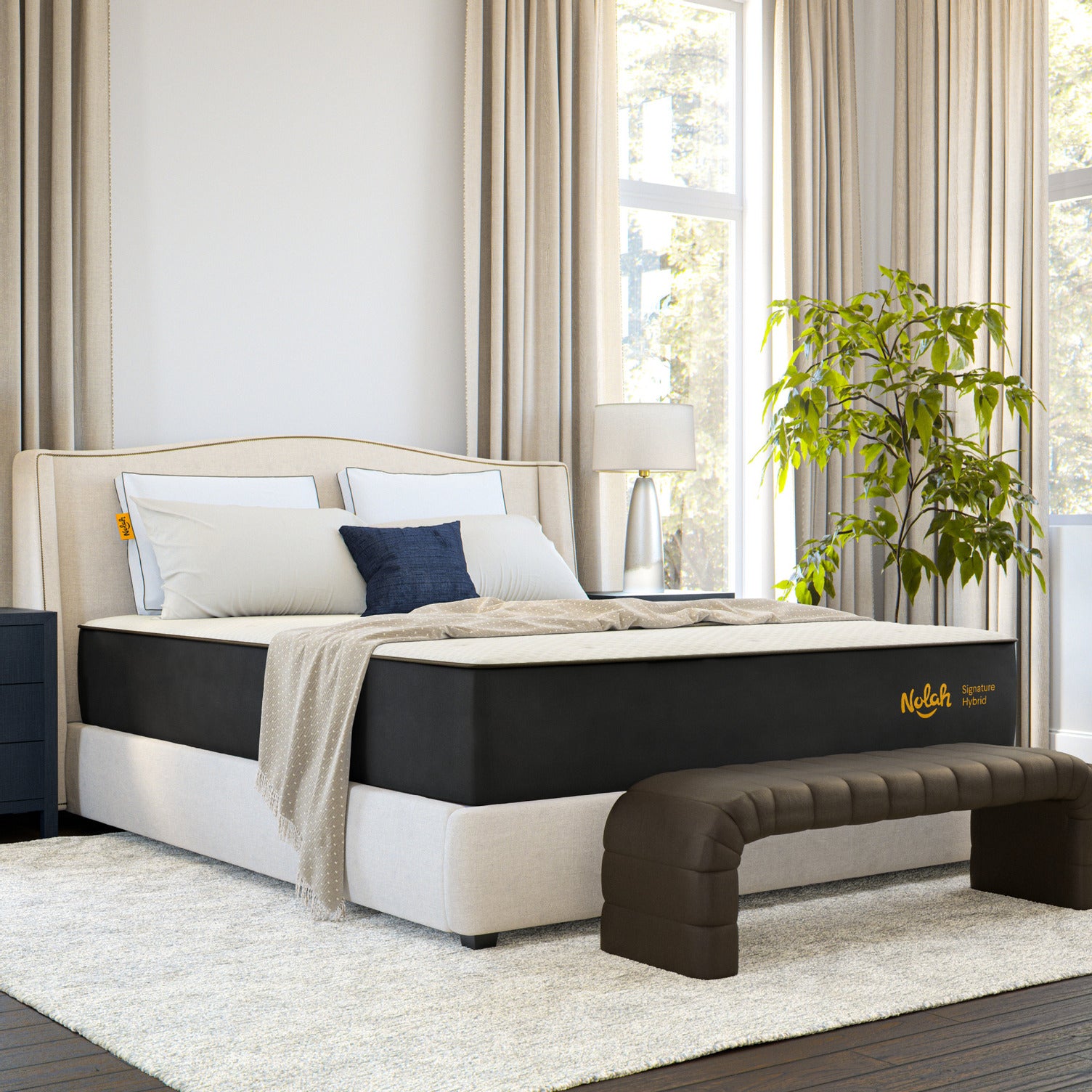 Bedroom with a featuring Nolah mattress, pillows, and a plant near a window.