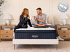 Couple sitting on a thermo balance mattress in a bedroom.